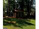 View of an exterior wooden shed in a backyard filled with trees at 963 Blackberry Ct, Ellenwood, GA 30294