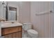 Standard bathroom featuring striped wallpaper, a toilet, and a vanity with a sink at 390 Stoneridge Way, Fayetteville, GA 30215