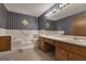 Bathroom featuring a soaking tub, double vanity, blue wallpaper, and diamond-shaped windows at 390 Stoneridge Way, Fayetteville, GA 30215
