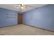 Bedroom with blue walls, neutral carpet, ceiling fan, shelving and a door at 390 Stoneridge Way, Fayetteville, GA 30215