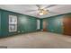 Large bedroom featuring neutral carpet, dark green walls, ceiling fan, and window allowing natural light at 390 Stoneridge Way, Fayetteville, GA 30215