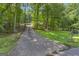 Long driveway leading to house, surrounded by trees and green lawn, with visible house number and mailbox at 390 Stoneridge Way, Fayetteville, GA 30215