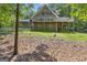 A two-story home with a large deck, surrounded by a lush, wooded landscape and greenery at 390 Stoneridge Way, Fayetteville, GA 30215