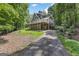 Two-story house with well-kept lawn and long driveway leading to the home, shaded by mature trees at 390 Stoneridge Way, Fayetteville, GA 30215