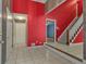 Bright foyer featuring tile flooring, staircase with carpet, and vibrant red walls with contrasting trim at 390 Stoneridge Way, Fayetteville, GA 30215