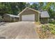 Two-car garage with a carport, adjacent to a landscaped yard, and a lengthy driveway at 390 Stoneridge Way, Fayetteville, GA 30215