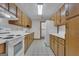 Galley kitchen featuring white appliances, light countertops, and wood cabinetry at 390 Stoneridge Way, Fayetteville, GA 30215