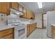 Galley kitchen featuring white appliances, light countertops, and wood cabinetry at 390 Stoneridge Way, Fayetteville, GA 30215
