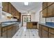 Open kitchen area boasting wooden cabinetry, tile flooring, and access to a bright sunroom at 390 Stoneridge Way, Fayetteville, GA 30215