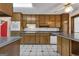 Traditional-style kitchen with wooden cabinets, white appliances, and black-and-white tile floors at 390 Stoneridge Way, Fayetteville, GA 30215