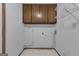 Functional laundry room with overhead cabinets, shelving, and tile flooring at 390 Stoneridge Way, Fayetteville, GA 30215