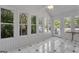 Bright sunroom with white paneling, black-and-white tiled floor, and views of the surrounding greenery at 390 Stoneridge Way, Fayetteville, GA 30215