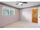 Bright bedroom features a ceiling fan, neutral carpet, double closet doors, and ample natural light at 829 Bev Ct, Lawrenceville, GA 30046
