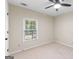 This bedroom includes a ceiling fan, neutral walls and carpet, and a window with blinds at 829 Bev Ct, Lawrenceville, GA 30046