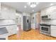 Spacious kitchen with white cabinets, stainless steel appliances, and a view to the living room at 829 Bev Ct, Lawrenceville, GA 30046