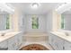 Bathroom featuring double vanities, a soaking tub, and a window providing natural light at 829 Bev Ct, Lawrenceville, GA 30046