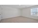 Neutral bedroom offers natural light from window, plush carpet, and white painted walls at 8587 Secretariat Dr, Lithonia, GA 30058