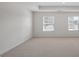 Inviting bedroom with neutral carpet, two windows, and bright wall paint at 8587 Secretariat Dr, Lithonia, GA 30058