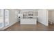 Open-concept kitchen with island, stainless steel appliances, and a view of the backyard through French doors at 8587 Secretariat Dr, Lithonia, GA 30058