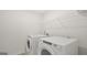 Bright laundry area features modern appliances, overhead shelving and white painted walls at 8587 Secretariat Dr, Lithonia, GA 30058