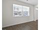 Bright living room featuring hardwood floors, a large window with blinds, and white walls at 8587 Secretariat Dr, Lithonia, GA 30058
