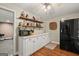 Basement bar with granite countertops, wooden shelves and stainless-steel refrigerator at 9125 Patrick Pl, Winston, GA 30187