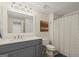 Neutral bathroom featuring a gray vanity, large mirror, and tiled shower with leaf patterned curtain at 9125 Patrick Pl, Winston, GA 30187