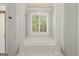 Bright bathroom featuring a tub with columns and plantation shutters for natural light at 9125 Patrick Pl, Winston, GA 30187