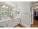 Bathroom featuring dual vanities, framed mirrors, hardwood floors and access to walk-in closet at 9125 Patrick Pl, Winston, GA 30187