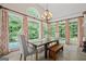 Sunlit dining area with a wood table, bench seating, floor-to-ceiling windows, and views of the backyard pool at 9125 Patrick Pl, Winston, GA 30187