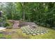 Picturesque backyard firepit area with stone seating, lush landscaping, and serene ambiance at 9125 Patrick Pl, Winston, GA 30187