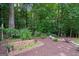 Charming garden area with raised beds and a stone pathway amid mature trees at 9125 Patrick Pl, Winston, GA 30187