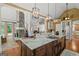 Open kitchen featuring an island with granite countertops, stainless steel appliances, and an adjacent stone fireplace at 9125 Patrick Pl, Winston, GA 30187
