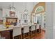 An open-concept kitchen features a large island, barstool seating, stainless steel appliances and oversized windows at 9125 Patrick Pl, Winston, GA 30187
