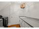 Convenient laundry room featuring front load machines, counter space, and storage cabinets at 9125 Patrick Pl, Winston, GA 30187