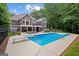 Inviting backyard pool area surrounded by lush trees, deck, and well-manicured lawn at 9125 Patrick Pl, Winston, GA 30187