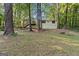 Back of house with deck surrounded by lush green trees at 260 Pinehurst Dr, Stockbridge, GA 30281