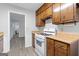 Practical kitchen offering white appliances, wood cabinets, and convenient access to the hallway at 260 Pinehurst Dr, Stockbridge, GA 30281
