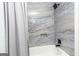Bathroom tub with a blue stone tile surround and black rainfall shower head at 650 Lynhurst Sw Dr, Atlanta, GA 30311