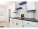 Kitchen details with white cabinetry, open shelving, and dark countertops at 650 Lynhurst Sw Dr, Atlanta, GA 30311
