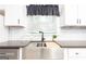 Kitchen with a stainless steel farmhouse sink, black faucet, and marble backsplash at 650 Lynhurst Sw Dr, Atlanta, GA 30311