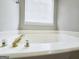 Close-up shot of a bathtub featuring crystal knobs, white porcelain, and a window view at 537 Goldfinch Way, Stockbridge, GA 30281
