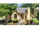 Charming stucco home featuring a red front door, mature trees, and a well-manicured lawn at 110 Tamerlane, Peachtree City, GA 30269