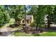 Exterior of a charming home with a well-manicured lawn, mature trees, and a circular driveway at 110 Tamerlane, Peachtree City, GA 30269