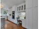 Well-lit kitchen with white cabinets, stainless steel appliances, desk area and hardwood floors at 110 Tamerlane, Peachtree City, GA 30269