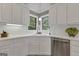 Kitchen sink featuring white cabinetry, stainless steel appliances, and a corner window at 110 Tamerlane, Peachtree City, GA 30269