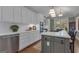 Bright kitchen features white cabinets, stainless steel appliances, and a large island with cooktop at 110 Tamerlane, Peachtree City, GA 30269