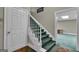 Carpeted staircase with white wooden trim and a door, leading to the basement at 110 Tamerlane, Peachtree City, GA 30269