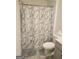 Shower and toilet in a bathroom with marble shower curtain and tile flooring at 160 Grafton St, Hampton, GA 30228