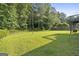 A lush green backyard offers plenty of space, surrounded by trees and greenery at 128 Southern Magnolia Ln, Rex, GA 30273